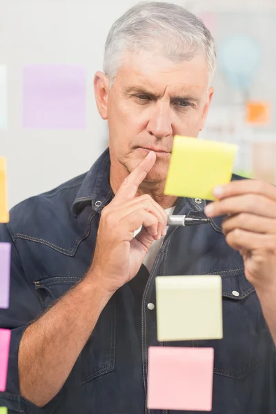 Casual businessman writing on post its — Stock Photo, Image