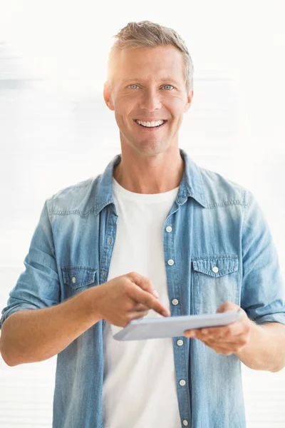 Homme d'affaires souriant défilant sur une tablette — Photo