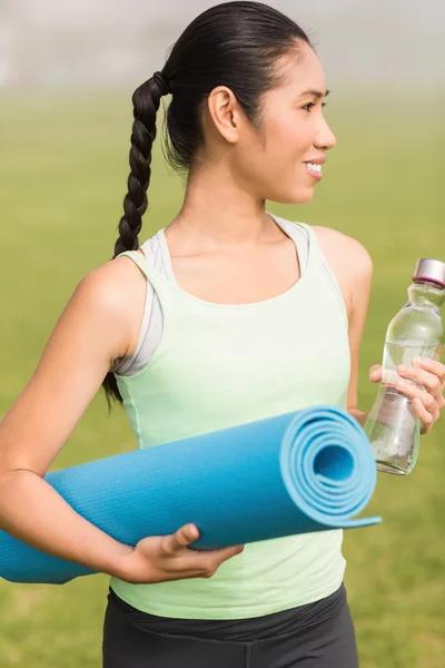 Deportiva mujer sosteniendo alfombra de ejercicio — Foto de Stock