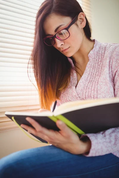 Brünette studiert am Fenster — Stockfoto