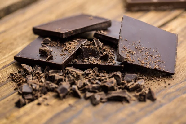 Pedazos de chocolate en una mesa de madera —  Fotos de Stock