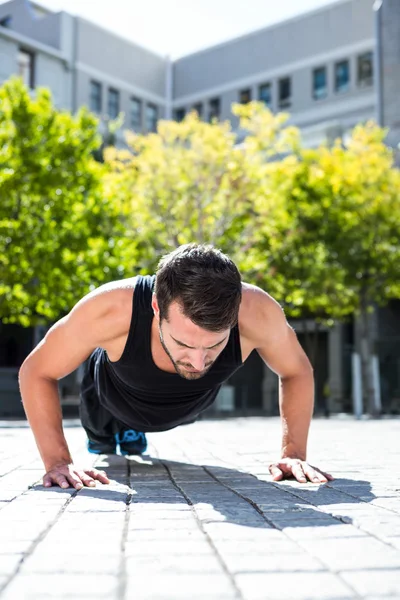 Athlete doing push-ups on the floor — Stock Photo, Image