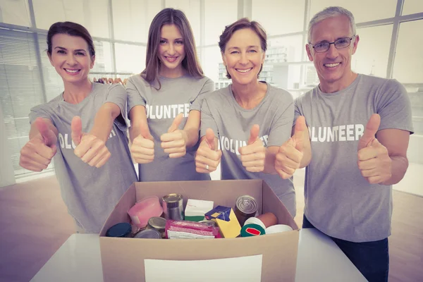 Voluntários sorrindo fazendo polegares para cima — Fotografia de Stock