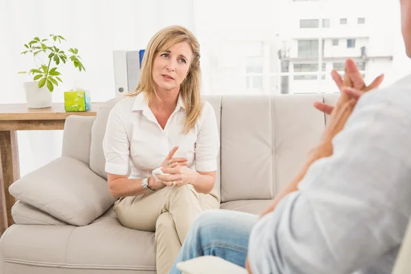 Unhappy woman sitting on couch — Stock Photo, Image