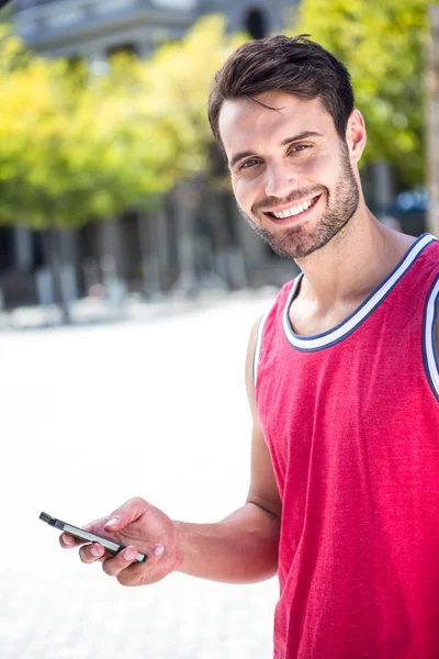 Handsome athlete sending a text — Stock Photo, Image