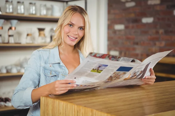 Sorrindo loira segurando jornal — Fotografia de Stock