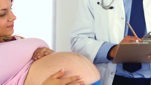 Arts praten met zijn zwangere patiënt — Stockvideo