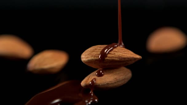 Chocolate derretido vertiendo sobre almendras — Vídeo de stock