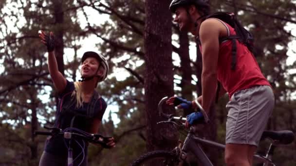 Par cykling genom en skog — Stockvideo
