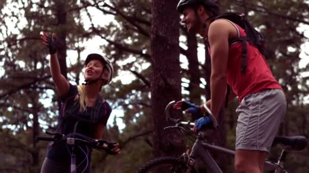 Pareja en bicicleta a través de un bosque — Vídeos de Stock