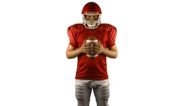 Красный американский футболист держит мяч — стоковое видео