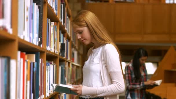 Estudiantes leyendo en una biblioteca — Vídeos de Stock