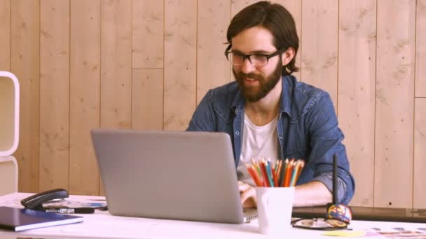 Toevallige werknemer achter zijn bureau met behulp van laptop — Stockvideo