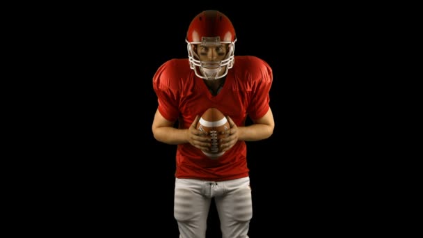 Jogador de futebol americano vermelho segurando uma bola — Vídeo de Stock
