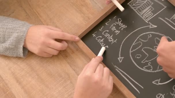 Business team drawing on a blackboard — Stock Video