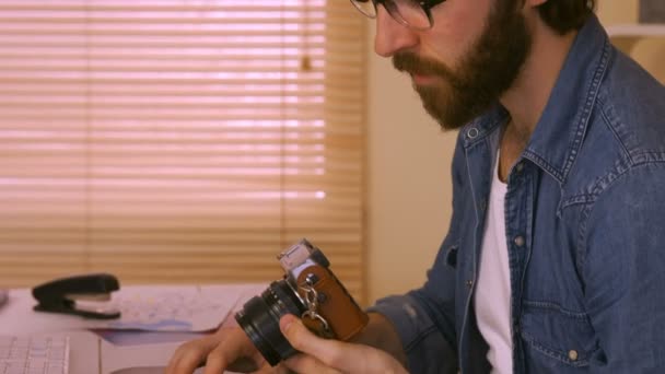 Фоторедактор, работающий за его столом — стоковое видео