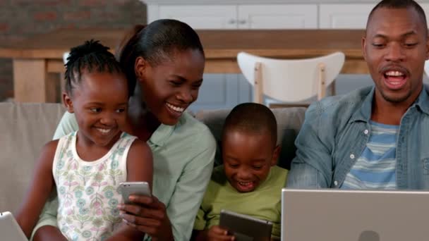 Familie mit Mediengeräten auf der Couch — Stockvideo