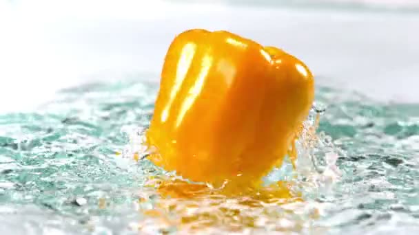 Yellow pepper spinning on water — Stock Video