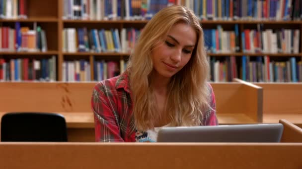 Hallgató dolgozik a laptop a könyvtárban — Stock videók