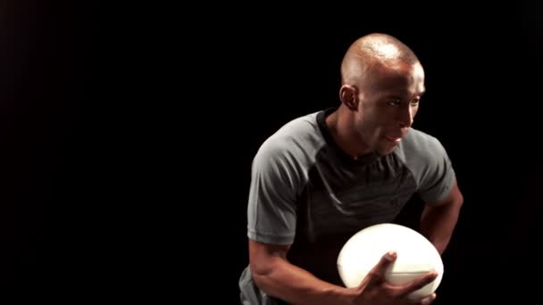 Un joueur de rugby sérieux court et tient une balle de rugby — Video