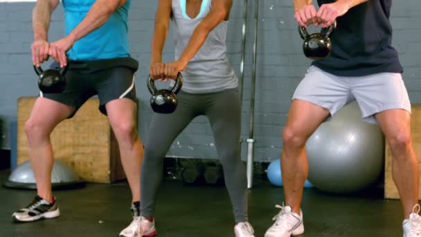 Fit pessoas levantando kettlebells no ginásio — Vídeo de Stock