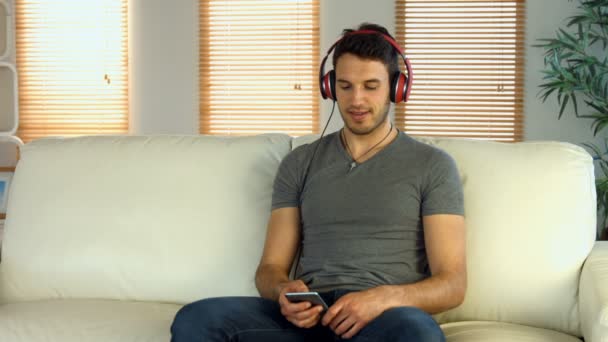 彼の携帯電話で音楽を聞いている男性 — ストック動画