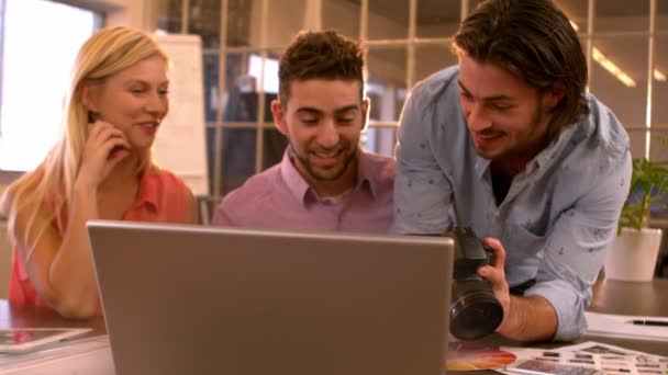 Hombre de negocios mostrando compañeros de trabajo su cámara — Vídeos de Stock