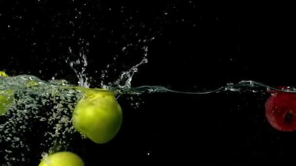 Яблоки падают в воду — стоковое видео