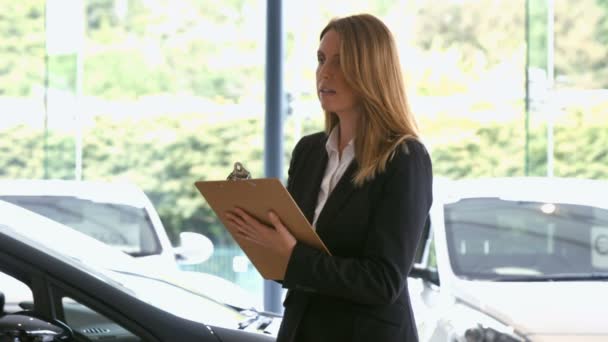 Femme d'affaires vérifiant une voiture — Video