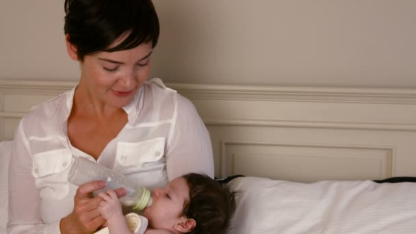 Bebê jovem bebendo de uma mamadeira de leite — Vídeo de Stock