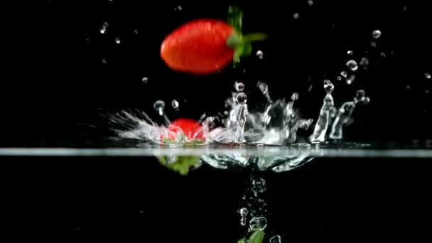 Strawberries falling in water — Stock Video