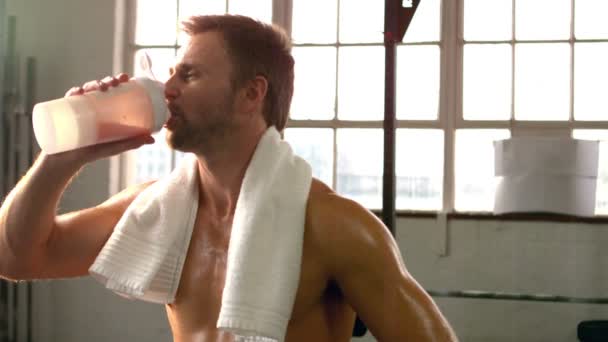 Přizpůsobit muž pití proteinový koktejl v tělocvičně — Stock video