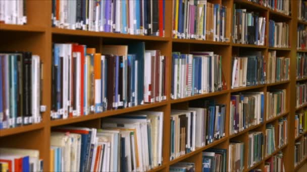 Estudiantes leyendo en una biblioteca — Vídeo de stock