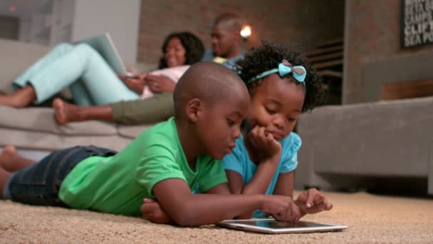 Geschwister nutzen Tablet-PC auf dem Fußboden — Stockvideo