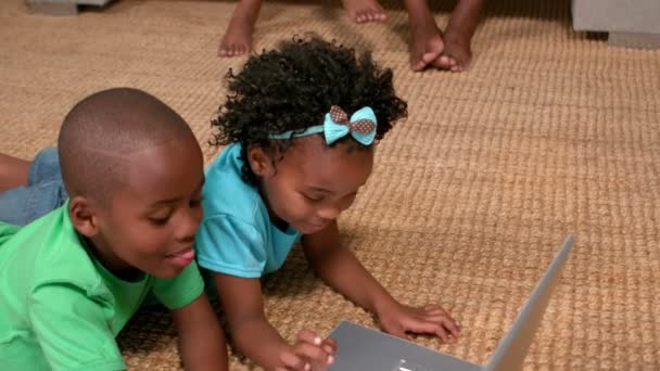 Irmãos usando laptop no chão — Vídeo de Stock