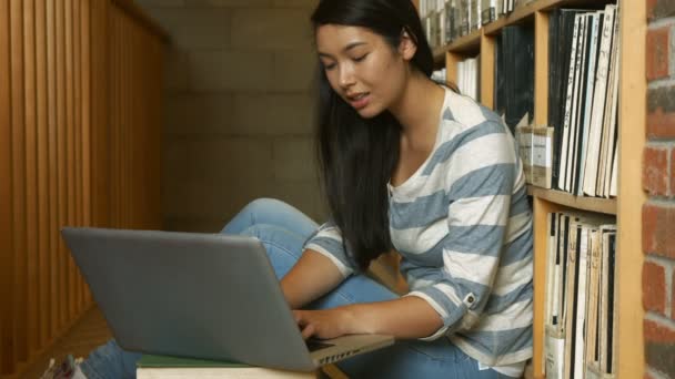 Diák laptop használ a könyvtárban — Stock videók
