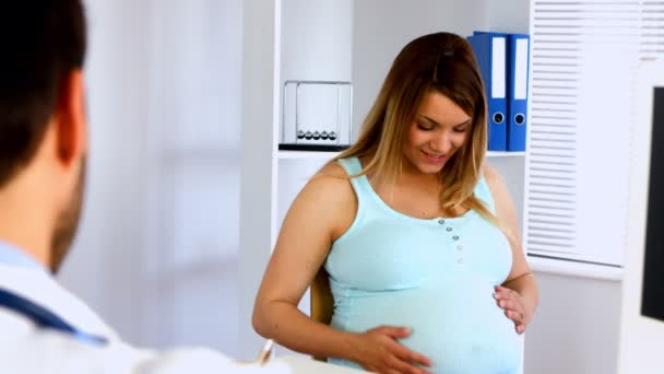 Беременная женщина разговаривает со своим врачом — стоковое видео