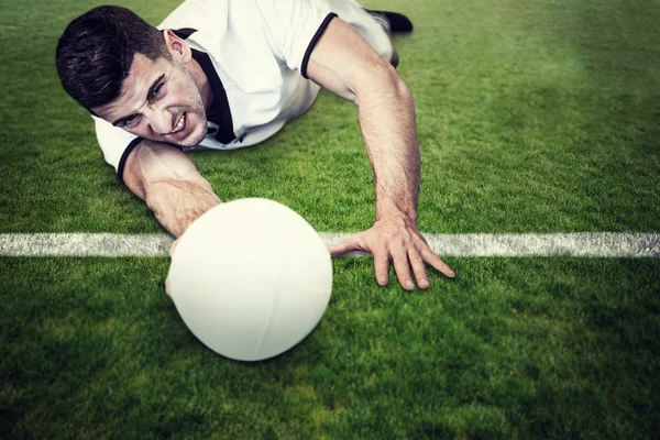 Człowiek w pozycji leżącej trzymając piłkę — Zdjęcie stockowe