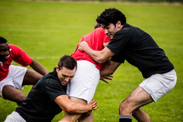 Rugbyspillere som tar tak i spillet – stockfoto