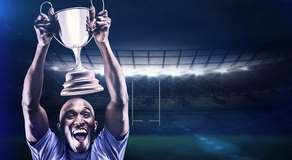 Athlete cheering while holding trophy — Stock Photo, Image