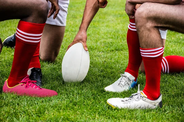 Jogadores de rugby em huddle com bola — Fotografia de Stock