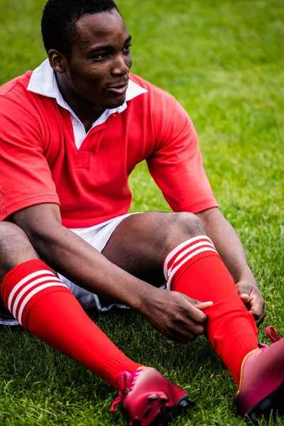 橄榄球运动员坐在草地上 — 图库照片