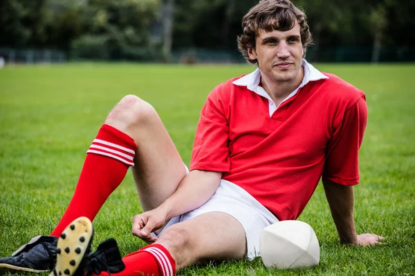 Jogador de rugby sentado na grama — Fotografia de Stock