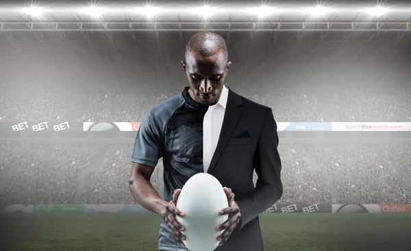 Спортсмен смотрит на регбийный мяч — стоковое фото