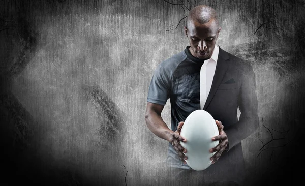 athlete looking at rugby ball