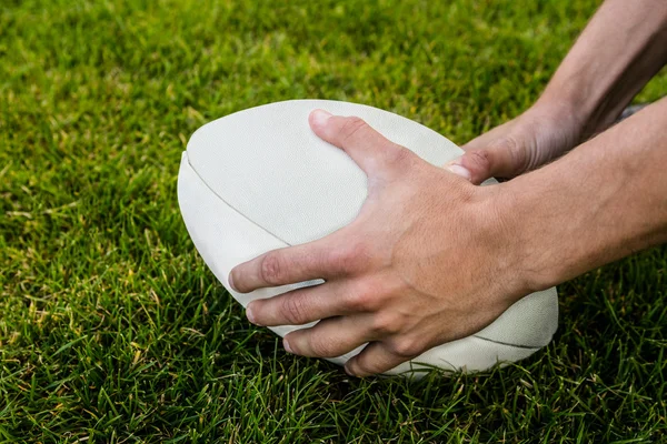 Rugby player picking up ball — Stock Photo, Image