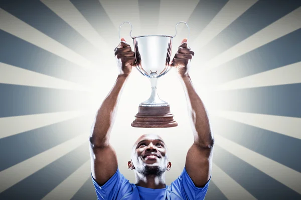 Desportista olhando para cima enquanto segurando troféu — Fotografia de Stock