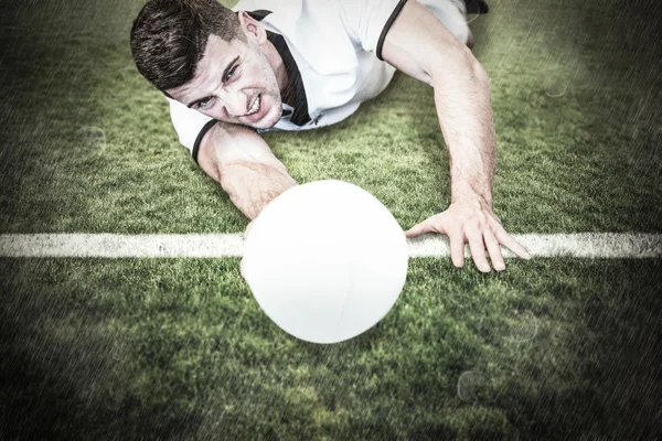 Mann legt sich hin, während er Ball hält — Stockfoto