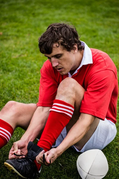 Jogador de rugby amarrando seu cadarço — Fotografia de Stock