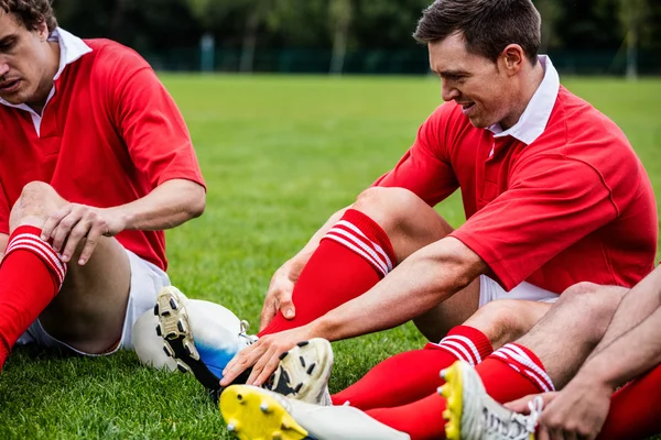 Graczy rugby, siedząc na trawie — Zdjęcie stockowe
